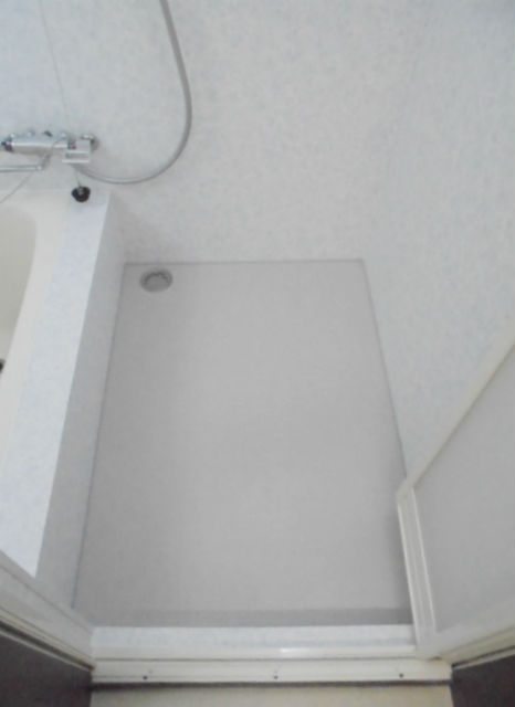 天井の形状に合わせてパネルとシートを巧みに使った階段下の浴室施工後イメージ１
