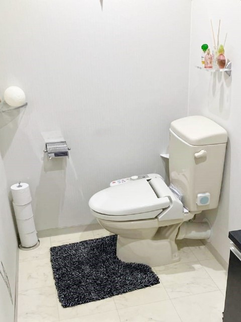 ホワイトグレーのトイレがシックな内装に調和するレストルーム施工後イメージ１